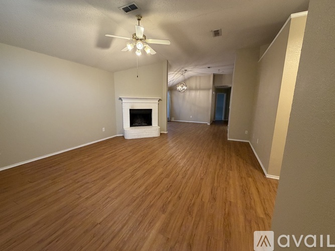 A room with wooden flooring and a fireplace.
