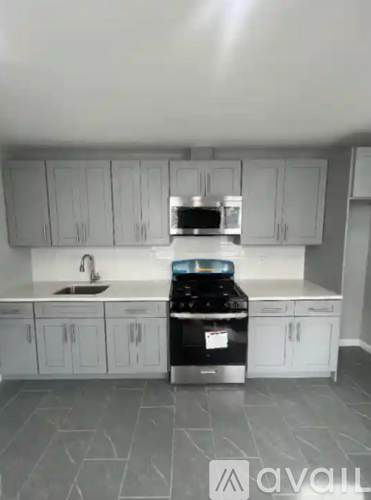 A kitchen with white cabinets and a black stove top oven.