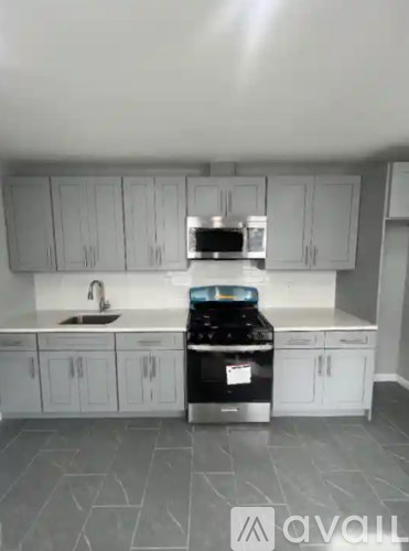 A kitchen with white cabinets and a black stove top oven.