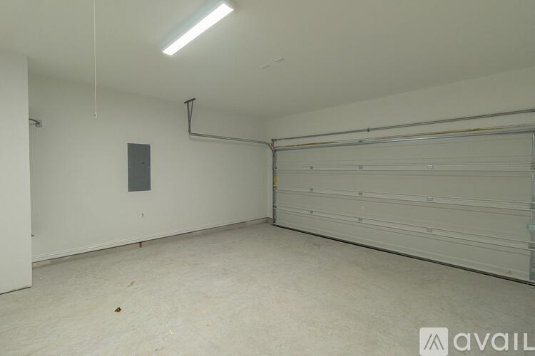 A spacious garage with a white wall and a closed white door.