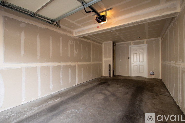 A room with a white door and a grey floor.