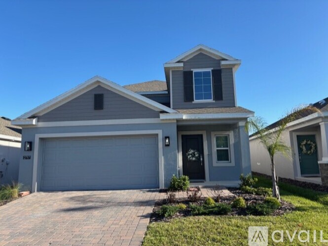A house with a garage and a driveway in front.