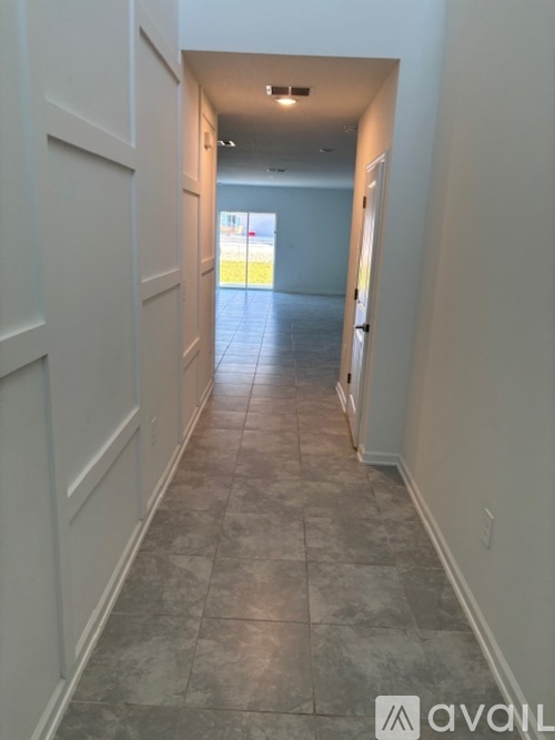 A long hallway with tiled floors and white walls.