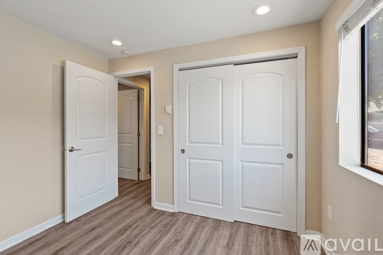 A room with two white doors and a window.