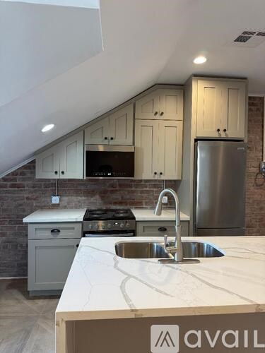 A kitchen with a sink, stove, and cabinets.