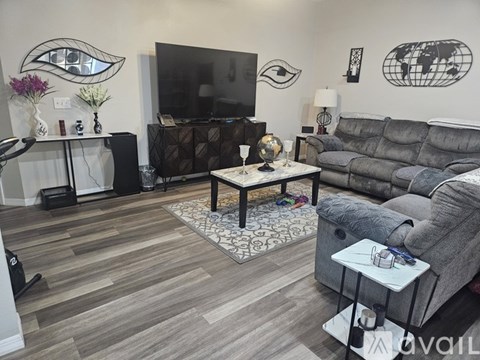 A living room with a grey couch and a wooden coffee table.