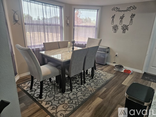 A dining room with a table and chairs.