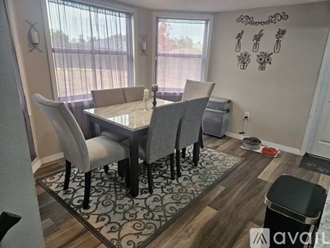 A dining room with a table and chairs.