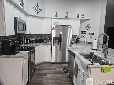 A kitchen with a refrigerator, sink, and oven.