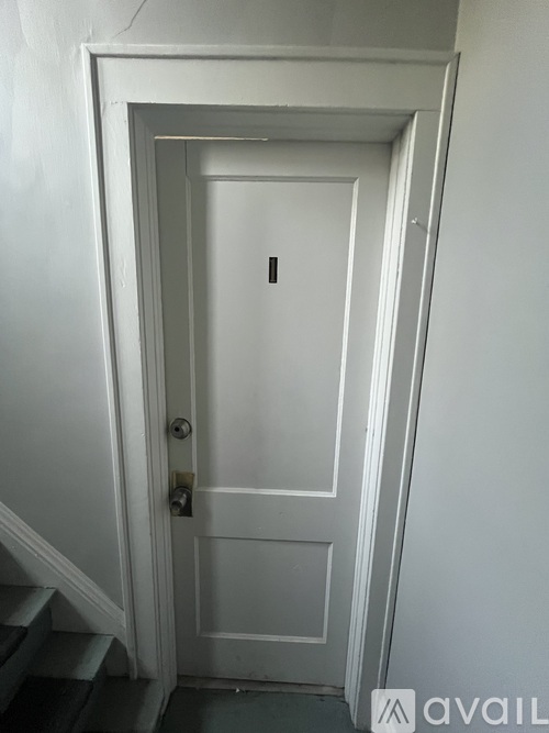 A white door with a black handle and a keyhole.
