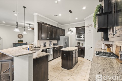 A modern kitchen with dark brown cabinets and a white island.