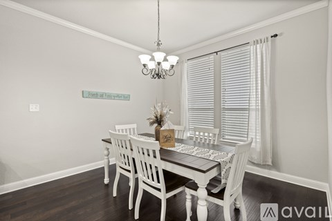 A dining room with a white table and chairs.