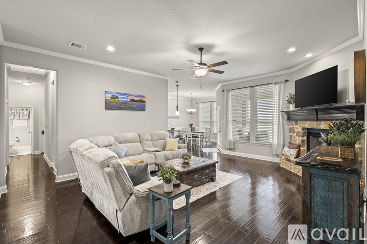 A living room with a white couch and a painting on the wall.