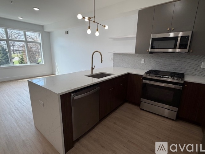 A modern kitchen with a large island and stainless steel appliances.
