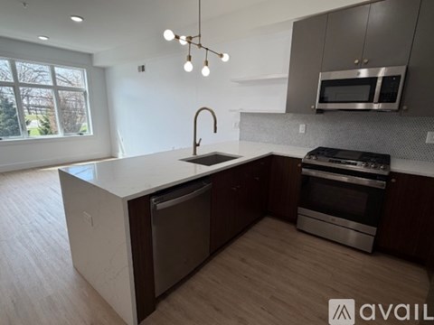 A modern kitchen with a large island and stainless steel appliances.