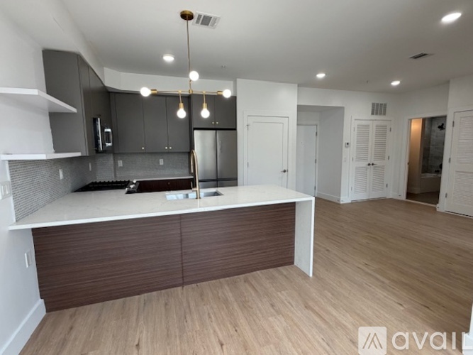 A modern kitchen with a white countertop and dark brown cabinets.