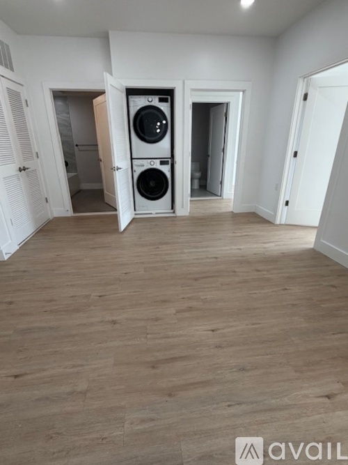A room with a washing machine and dryer in the doorway.