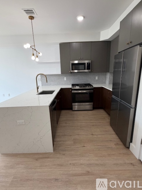 A modern kitchen with a marble island and stainless steel appliances.