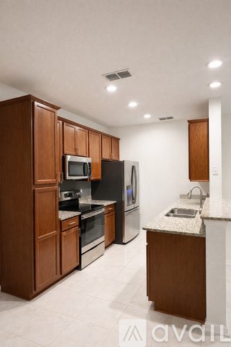 A kitchen with wooden cabinets and black appliances.