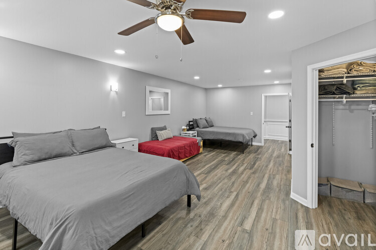 A bedroom with a large bed and a smaller bed in the background.