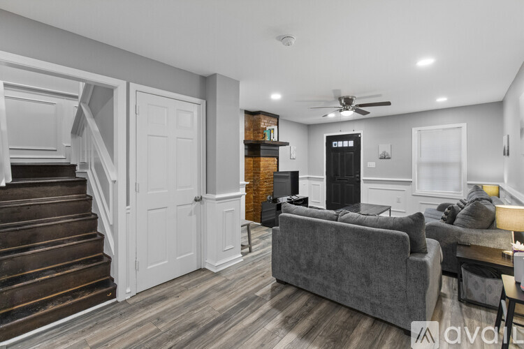 A living room with a grey couch and a staircase.