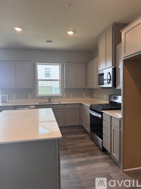A kitchen with a white countertop and a stove top oven.