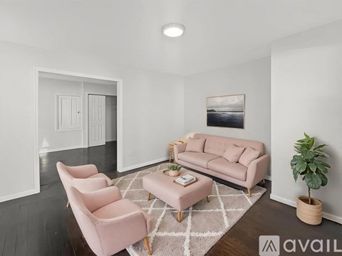 A living room with a pink sofa, two chairs and a coffee table.