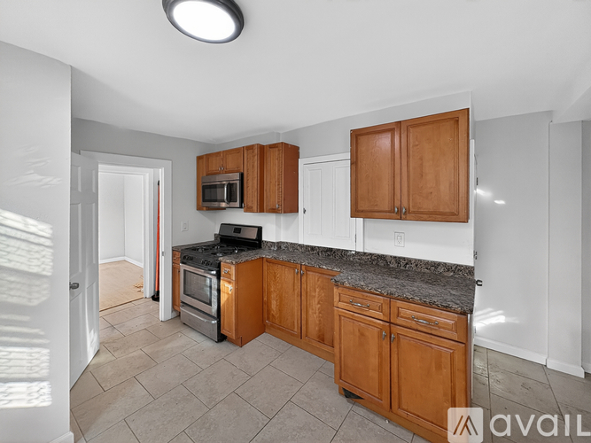 A kitchen with wooden cabinets and a granite countertop.