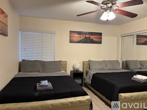 A bedroom with two beds and a ceiling fan.