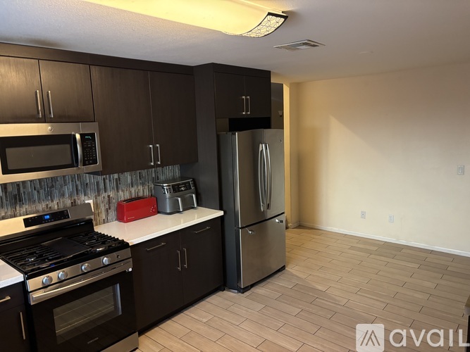 A kitchen with a stove, microwave, and refrigerator.