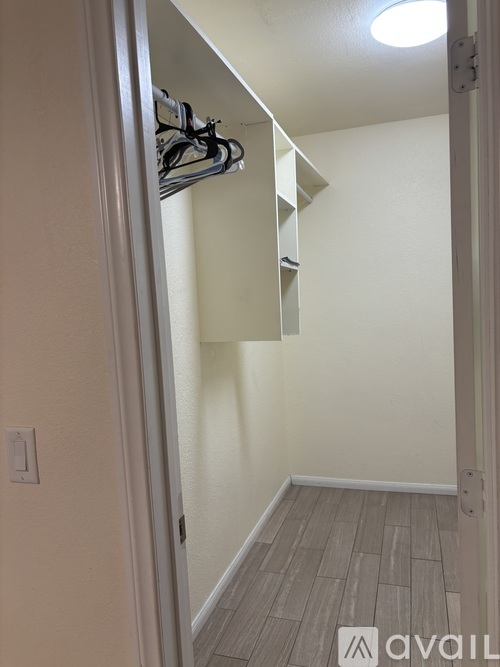 A hallway with a coat rack and a light switch on the wall.
