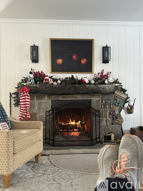 A cozy living room with a fireplace and a painting above it.