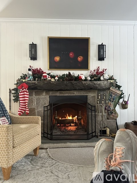 A cozy living room with a fireplace and a painting above it.