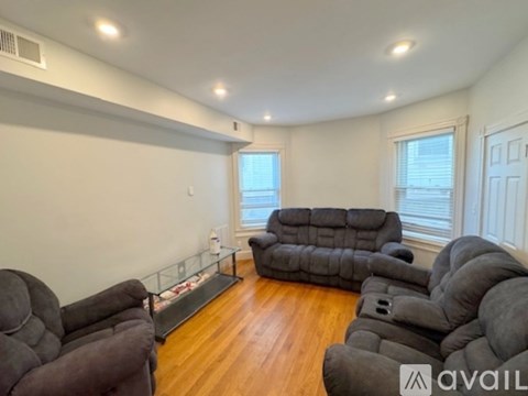 A living room with a grey couch and a glass coffee table.