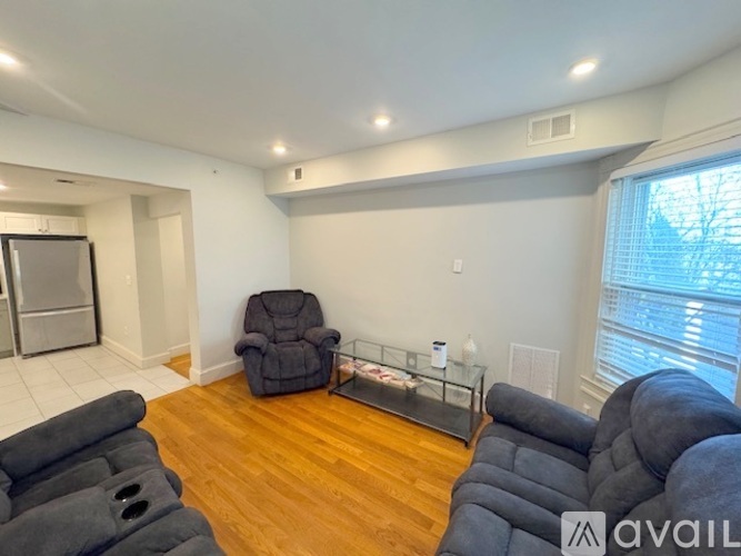 A living room with a black recliner and a black sofa.