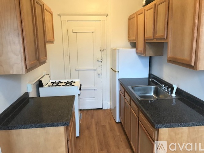 A kitchen with wooden cabinets and a black countertop.