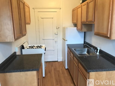 A kitchen with wooden cabinets and a black countertop.