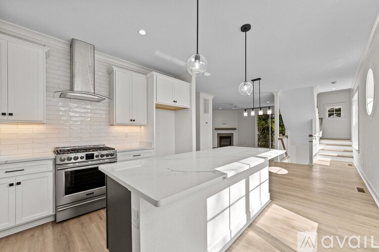 A modern kitchen with white cabinets and a large island.