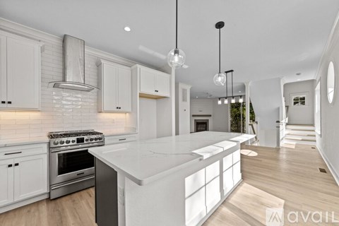 A modern kitchen with white cabinets and a large island.