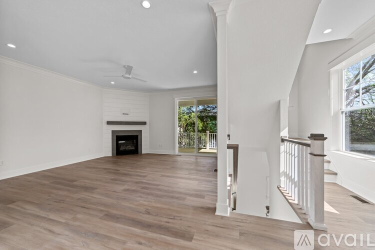 A spacious living room with a fireplace and wooden flooring.