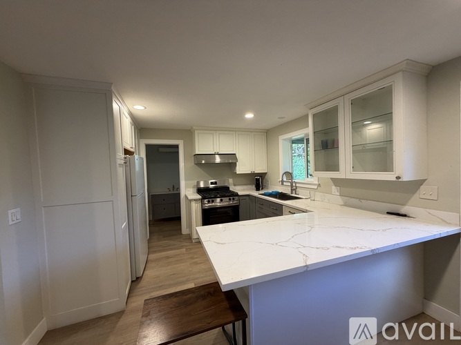 A kitchen with a white countertop and wooden flooring.