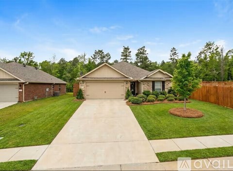 A house with a driveway and a tree in the front yard.