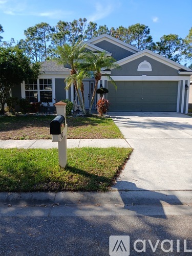 A house with a grey garage door and a mailbox in front.