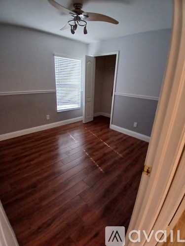 A room with wooden floors and a ceiling fan.