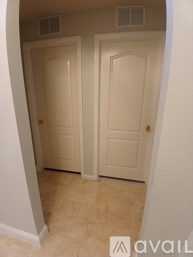 A hallway with two doors and a tiled floor.