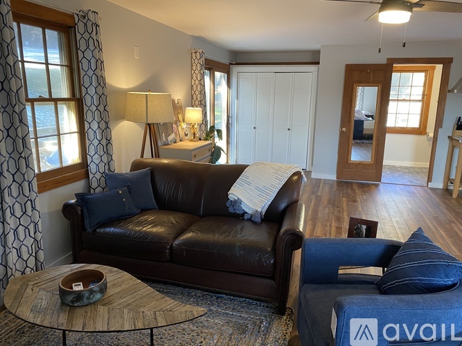 A living room with a brown leather couch and a wooden coffee table.