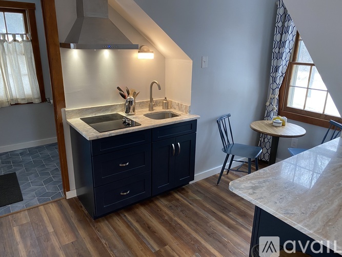 A kitchen with a sink, a stove, and a counter.