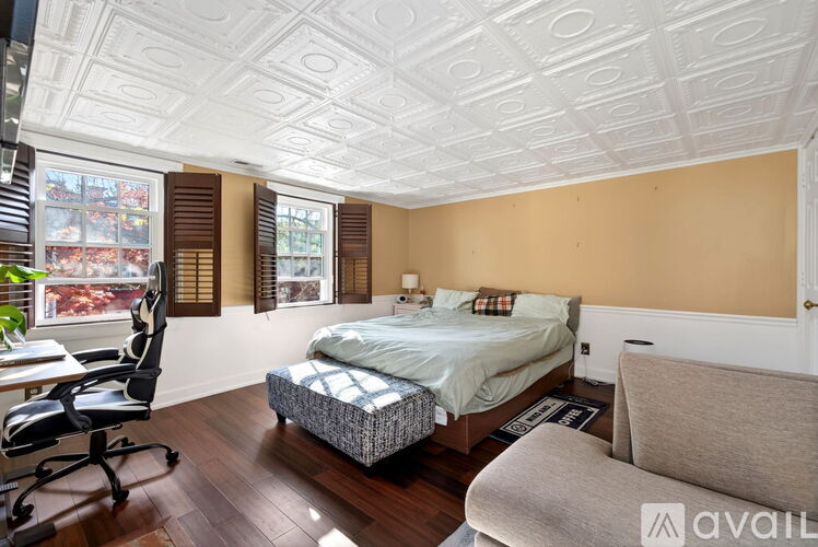 A bedroom with a bed, chair, and desk.