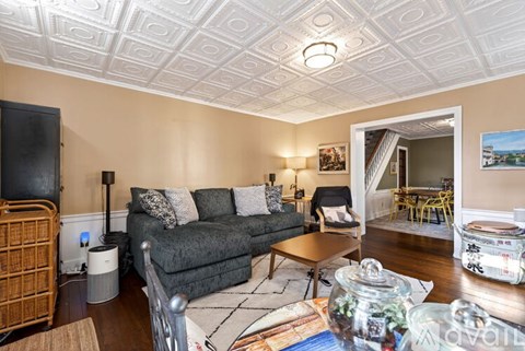 A living room with a grey couch and a wooden coffee table.