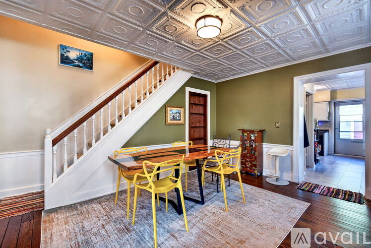 A dining room with a wooden table and chairs.